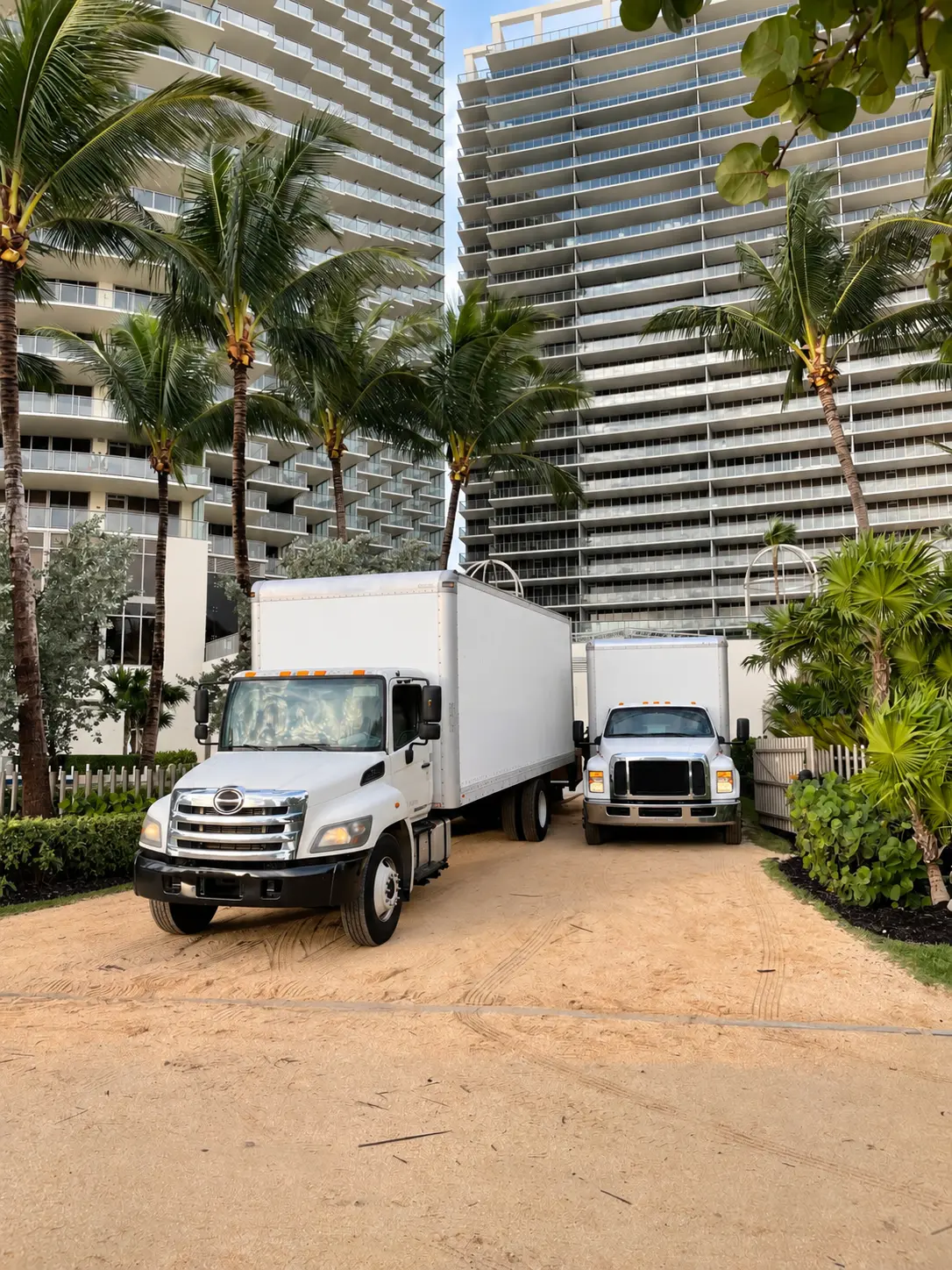 Two Meridian moving trucks at a Florida beach property